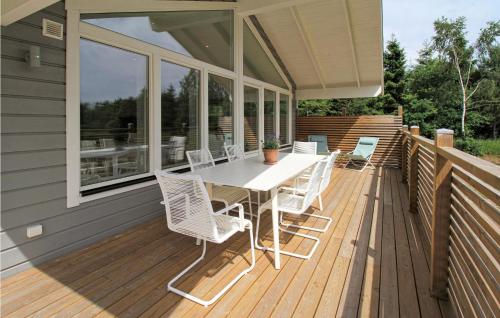 a wooden deck with a table and chairs on it at Gorgeous Home In Munka Ljungby in Munka-Ljungby