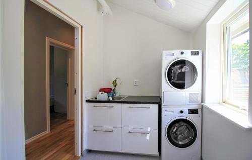 a laundry room with a washer and dryer next to a window at Gorgeous Home In Munka Ljungby in Munka-Ljungby
