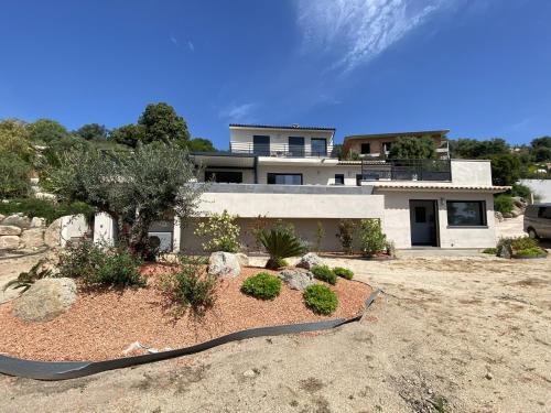 a house with a landscaping in front of it at Tres belle villa neuve vue mer avec piscine chauffee in Sainte-Lucie de Porto-Vecchio