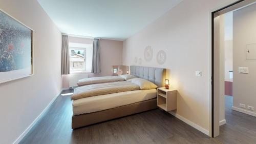 a bedroom with a large bed and a mirror at Reka-Ferienanlage Madulain in Madulain