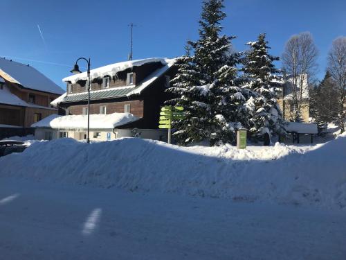 a pile of snow in front of a building at Zotavovna Kvilda in Kvilda