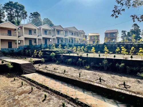 a row of houses with flowers in a garden at NEELGAGAN RESORT in Chaukori