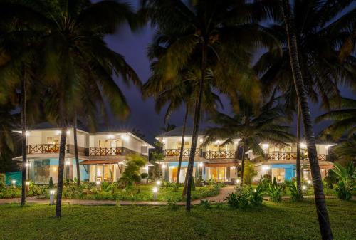 a resort with palm trees in front of it at Malabar Ocean Front Resort And Spa, Bekal in Nīleshwar