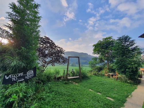 a gate in a field with a sign in the grass at La Beauté Bắc Hà in Bắc Hà