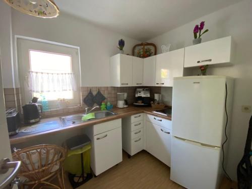 a kitchen with white cabinets and a white refrigerator at Ferienwohnung Chaves in Bad Karlshafen