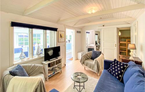 Una sala de estar con un sofá azul y un televisor. en Nice Home In Ängelholm With Wifi, en Ängelholm