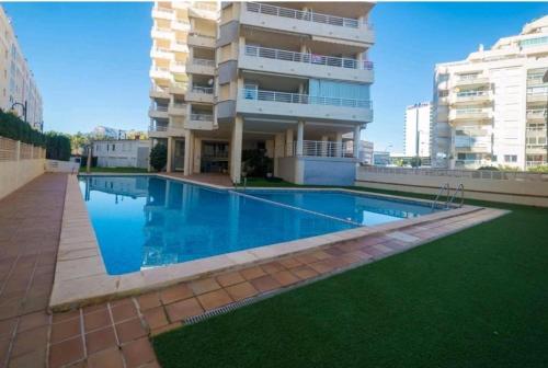 a swimming pool in front of a building at Apartamento Aquarium Park, 1ª linea de playa, piscina privada, aire acondicionado y wifi de alta velocidad in Calpe