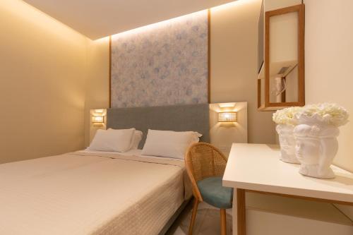 a bedroom with a bed and a table with a vase of flowers at Hotel Giosue' a mare Sorrento in Meta