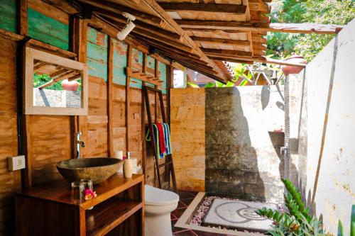 a bathroom with a sink and a toilet in a room at Villa Melasti Amed in Amed