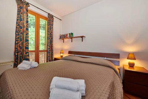 a bedroom with a bed with two towels on it at ApartmentsGarda - Baia D'Argento Residence in Costermano
