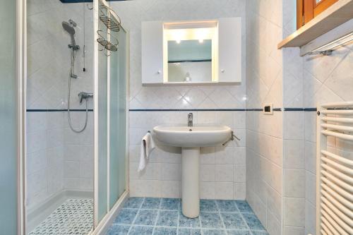 a white bathroom with a sink and a shower at ApartmentsGarda - Baia D'Argento Residence in Costermano