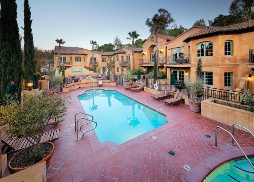 a large swimming pool with benches and a building at Hotel Los Gatos in Los Gatos