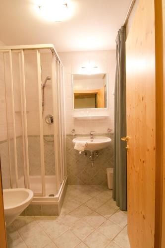 a bathroom with a sink and a shower at Pension Enzian in Badia