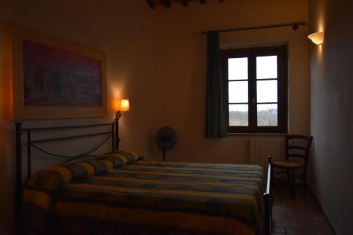 a bedroom with a bed and a window at Falesta in Casole dʼElsa