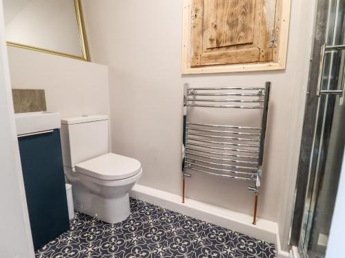 a bathroom with a toilet and a cabinet and a tile floor at Ley Mill Farm in Westbury on Severn
