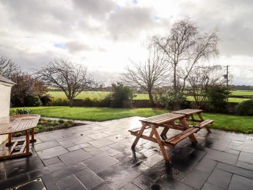a picnic table and bench on a stone patio at Ley Mill Farm in Westbury on Severn