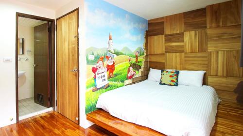 a bedroom with a bed with a painting on the wall at Sanyi Dream Garden B&B in Sanyi