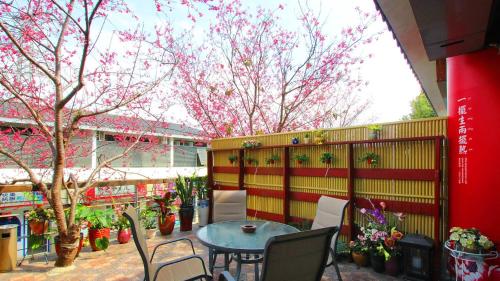 een tafel en stoelen voor een hek met bloemen bij Sanyi Dream Garden B&B in Sanyi