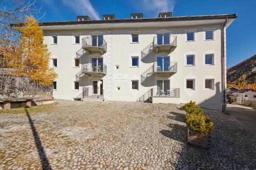 a large white building with balconies on it at Reka-Ferienanlage Madulain in Madulain