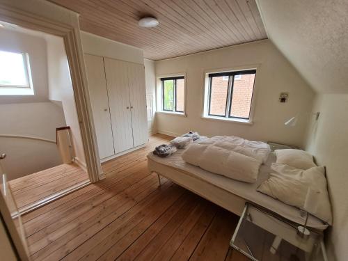 Un dormitorio con una cama en una habitación con suelo de madera. en (014) Frodesgade 129, en Esbjerg