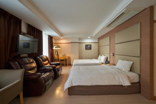 Gyeongju GG Tourist Hotel في جيونجو: غرفة فندقية بسريرين وتلفزيون بشاشة مسطحة