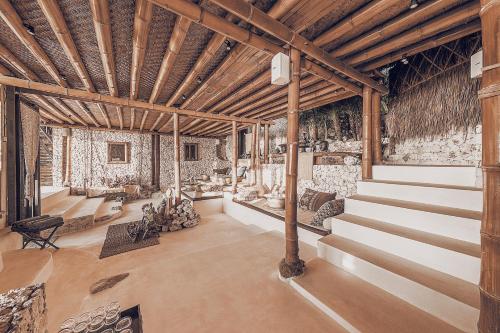 a room with wooden ceilings and stairs in a building at The Baha House in Uluwatu