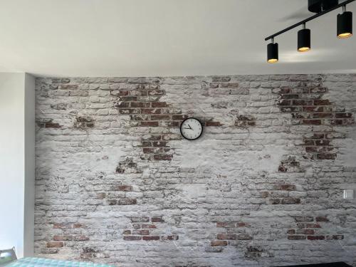 a brick wall with a clock on it at Kemi CITY III near snowcastle, premium 2 rooms , kitchen , glazed balcony, FREE private parking in Kemi