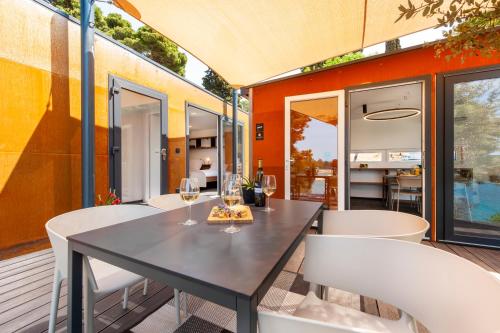 a dining room with a table and white chairs at Porton Nature Hideouts in Rovinj