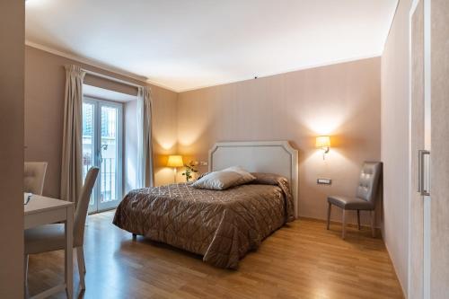 a bedroom with a bed and a table and a desk at Hotel Centrale in Olbia