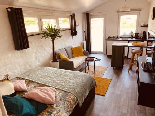 ein Schlafzimmer mit einem Bett, ein Wohnzimmer und eine Küche in der Unterkunft Ké dodo sous le château !!! in Spa