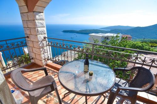 a glass table on a balcony with a view of the ocean at Apartments Villa Sveti Nikola in Budva