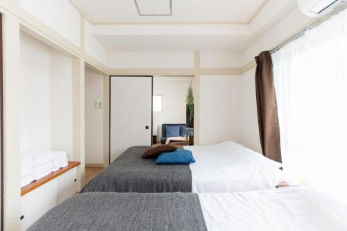 a bedroom with a bed and a large window at LUANAHOTEL IN WASEDA in Tokyo