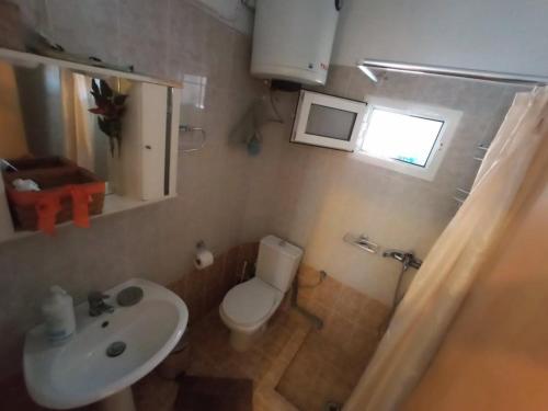 a small bathroom with a toilet and a sink at Gianna's House in Paradisos