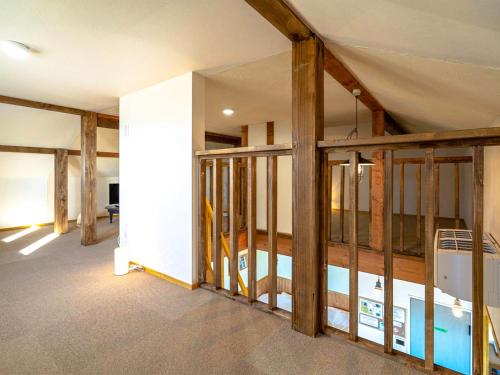 a room with unfinished walls and wood beams at Country Cottage Wakiaiai in Nakafurano