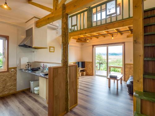 a kitchen and living room with wooden beams at Country Cottage Wakiaiai in Nakafurano