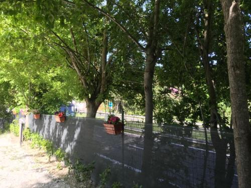 a fence with two flower pots on it next to trees at La casa dei ricordi in Acqualagna