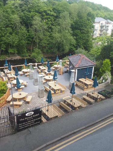 a group of tables and chairs with blue umbrellas at The Hand Hotel Llangollen by Compass Hospitality in Llangollen
