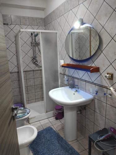 a bathroom with a sink and a toilet and a mirror at Camera a Palermo in Mondello