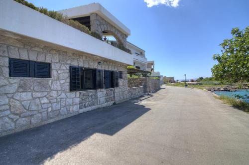 a stone wall next to a building next to a road at Casa al mare in Sveti Juraj