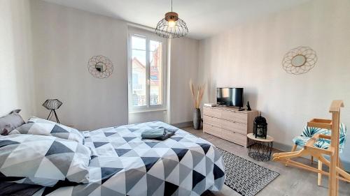 - une chambre avec un lit, une télévision et une chaise dans l'établissement Appartement F2 refait à neuf tout confort, à Montluçon