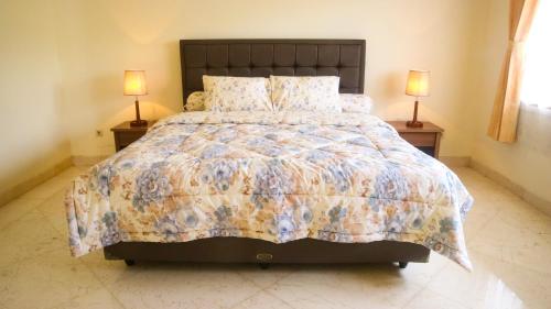 une chambre avec un grand lit avec deux lampes dans l'établissement Dago Asri House (3 Bedrooms, 6 Pax, 500m2), à Bandung