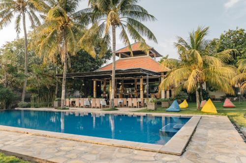 图兰奔Ocean View Tulamben Dive & Resort的有游泳池和棕榈树的度假村