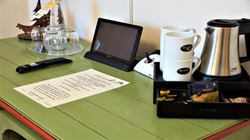 a green counter top with a laptop computer on it at Landkomforthotel Panorama & Restaurant Bella Vista in Garmisch-Partenkirchen