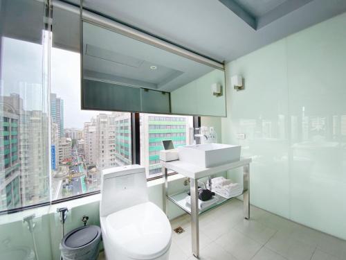 a bathroom with a toilet and a sink and a window at 安庭台北商旅 in Taipei