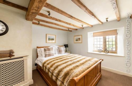 a bedroom with a bed and a window at Little Gables in Broadway