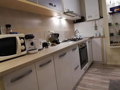 a kitchen with a microwave and a stove top oven at Tomis Apartament in Constanţa