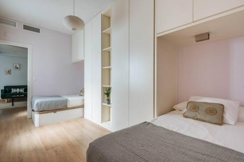 a bedroom with white walls and a bed in a room at Luz de Sevilla Free parking in Seville