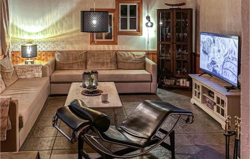 a living room with a couch and a tv at Awesome Home In Spangereid With Sauna in Spangereid