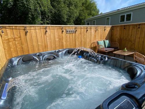 a hot tub in a backyard with a fence at Aintree Lodge - Hot Tub - Northumberland in Swarland