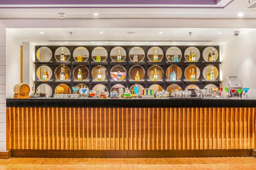 a bar in a restaurant with plates on shelves at Golden Tulip Jalandhar in Jalandhar